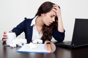 Sick woman at work with headache
